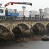 Retiran un tronco e arrastres do río na ponte do Burgo