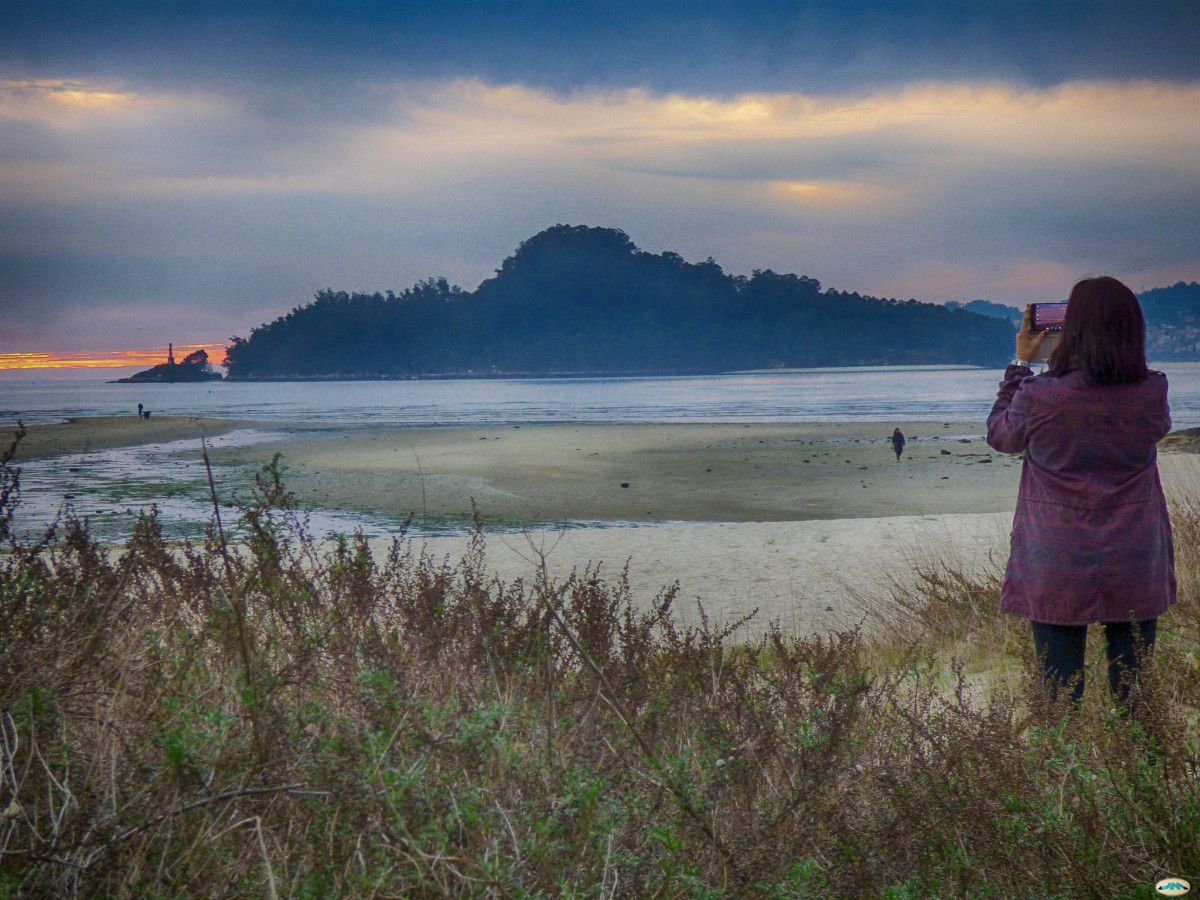 Una mujer sacando una foto a la isla de Tambo