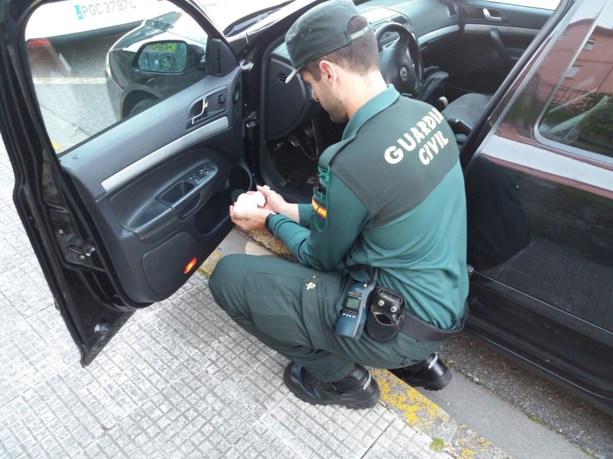 Un agente de la Guardia Civil revisando el vehículo del detenido