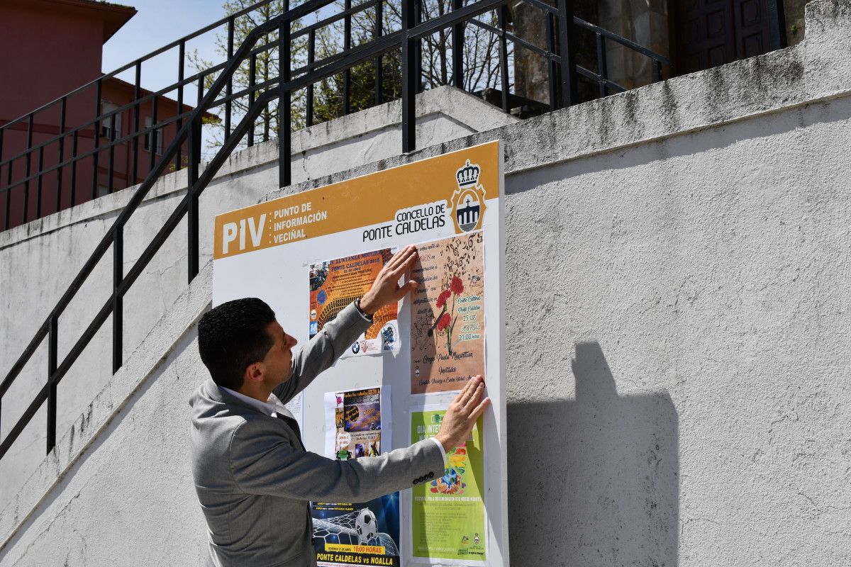 Andrés Díaz, alcalde de Ponte Caldelas, colocando un cartel nun Punto de Información Veciñal