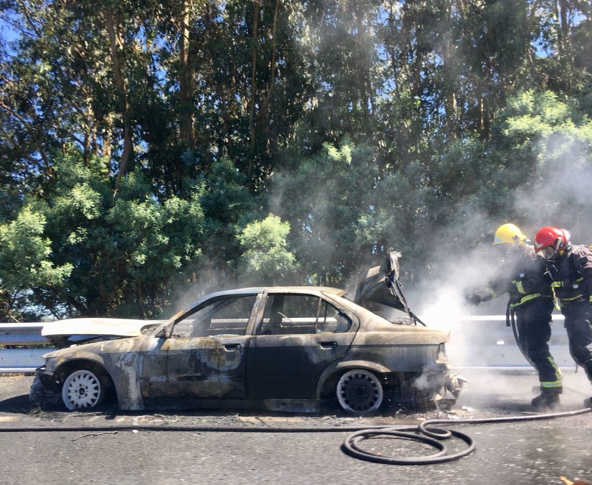 Bomberos apagando el fuego en el vehículo en la AP-9