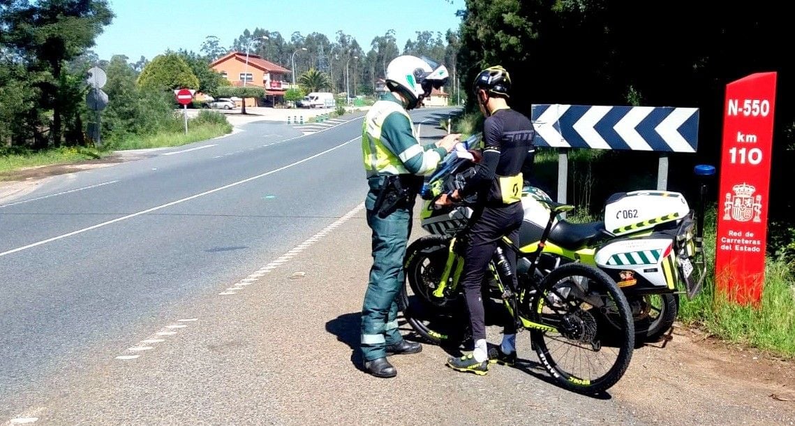 Agente de la Guardia Civil a ciclistas en la N-550