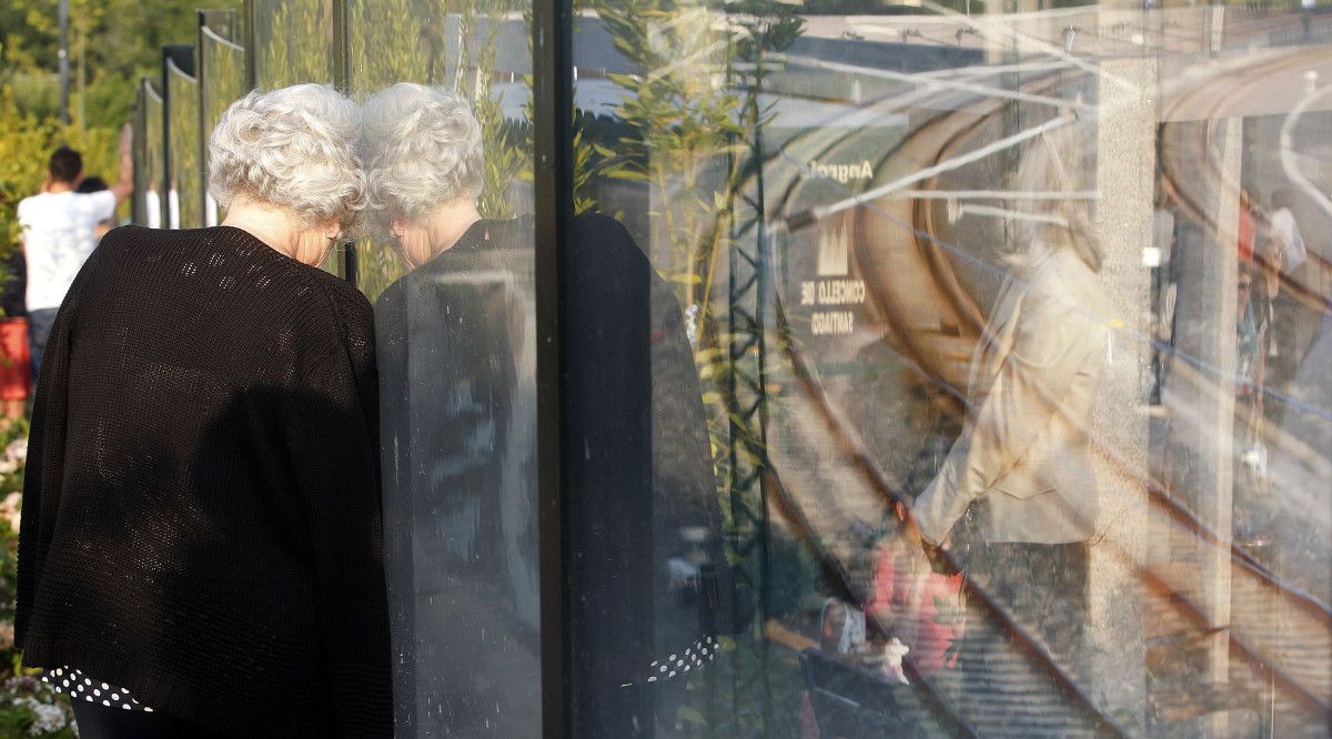 Una mujer observa las vías de Angrois durante el acto del primer aniversario del descarrilamiento del Alvia