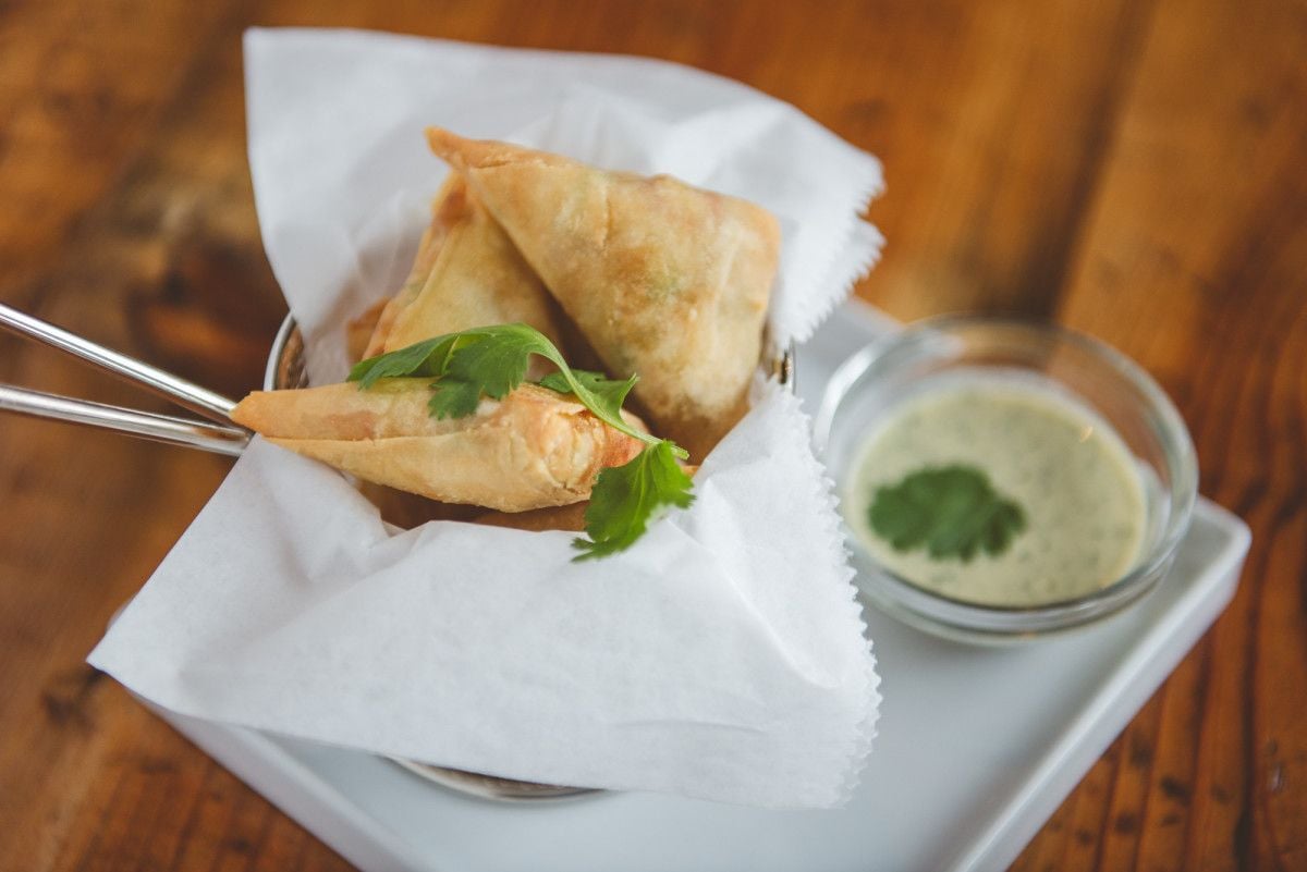 Samosas fritas acompañadas de salsa de yogur