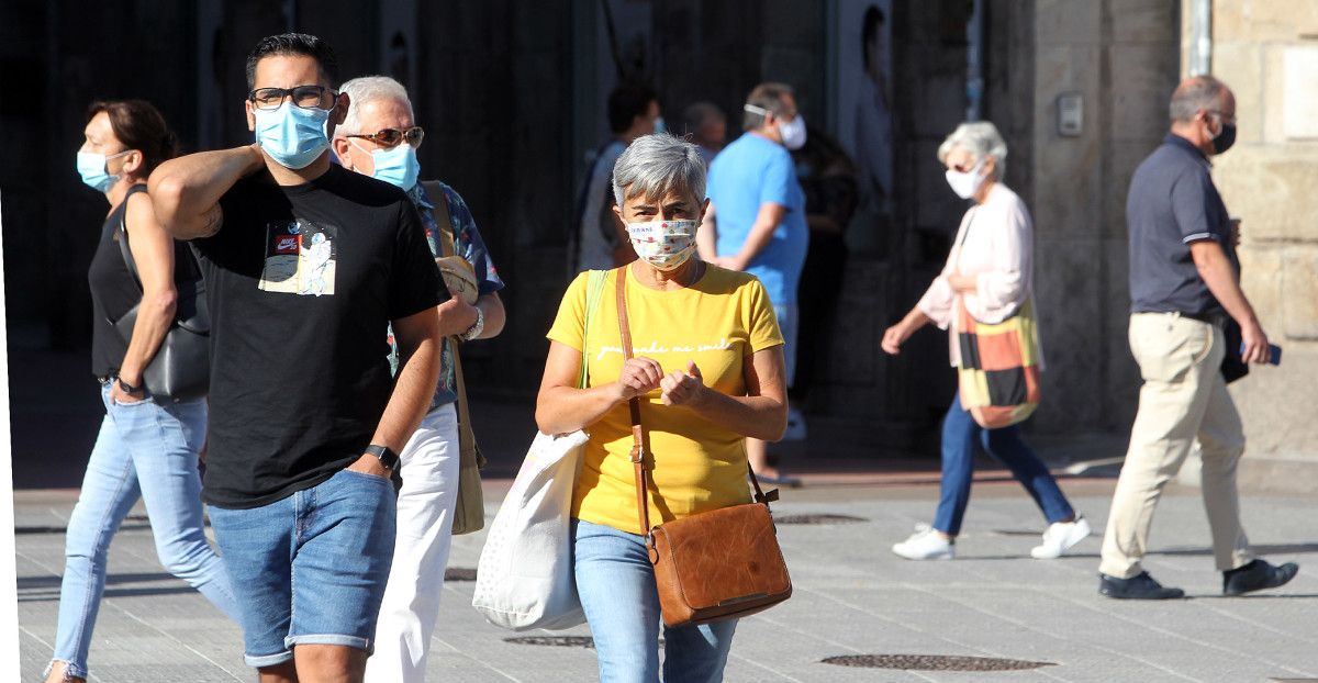 Gente paseando por la calle con mascarilla