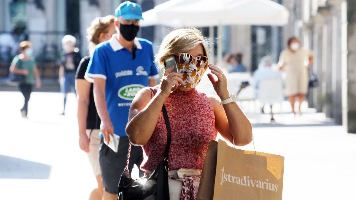 Gente paseando por la calle con mascarillas