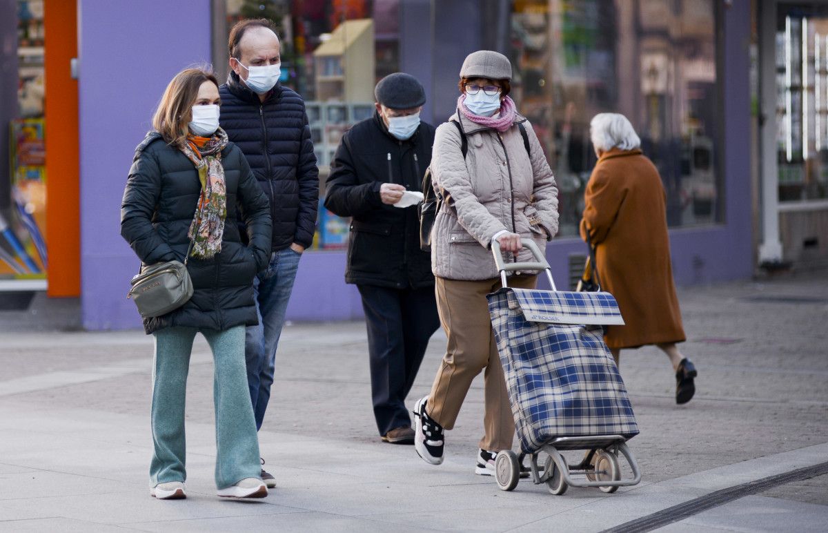 Gente paseando por la calle con mascarilla