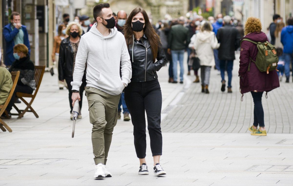 Gente paseando por la calle con mascarilla