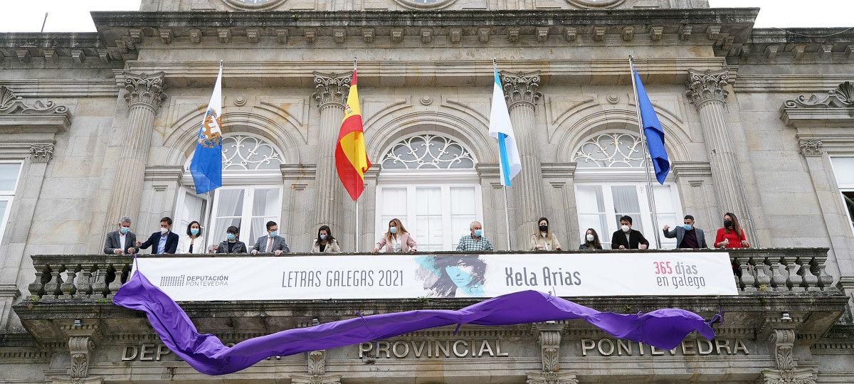 Representantes de la Deputación cuelgan la pancarta conmemorativa de las Letras Galegas en homenaje a Xela Arias