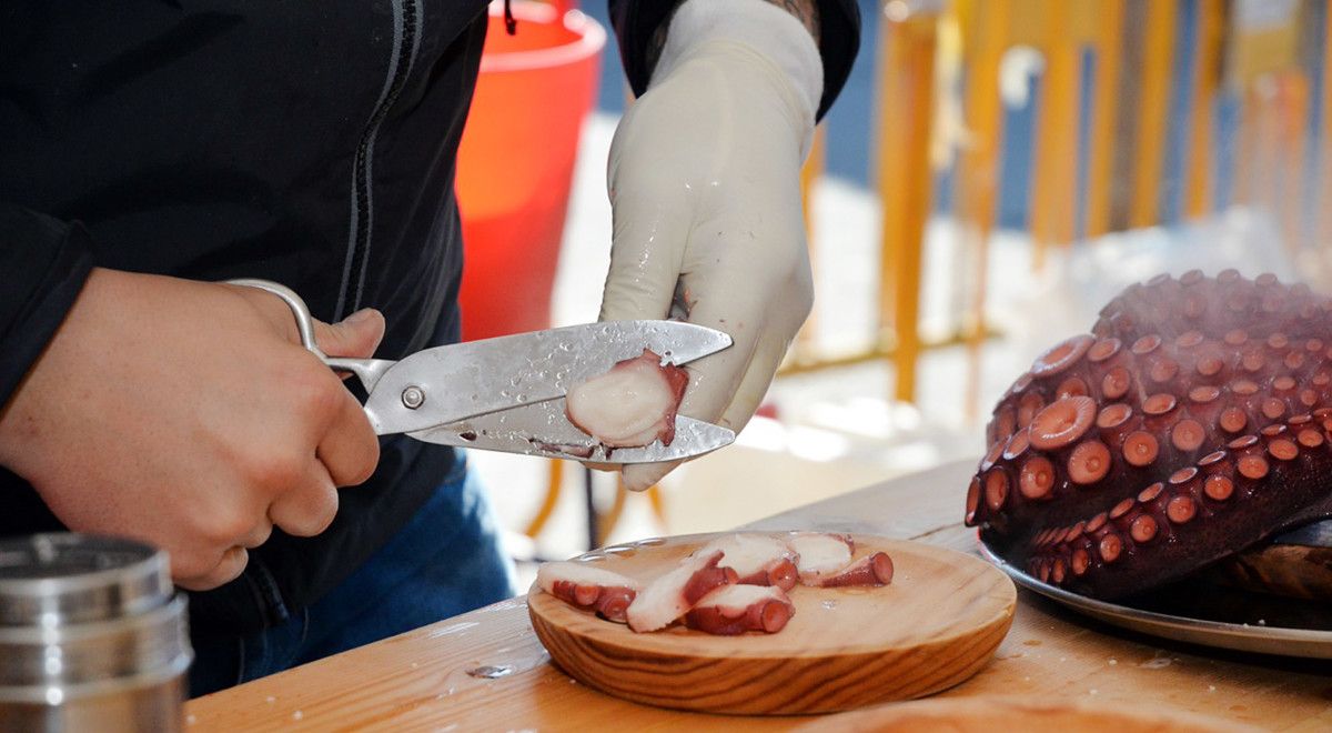 Una persona preparando el pulpo a la feria