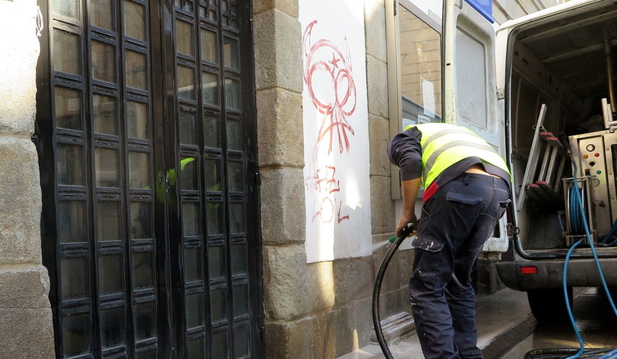 Un operario de Ferrovial limpia un graffiti en el lateral del Teatro Principal