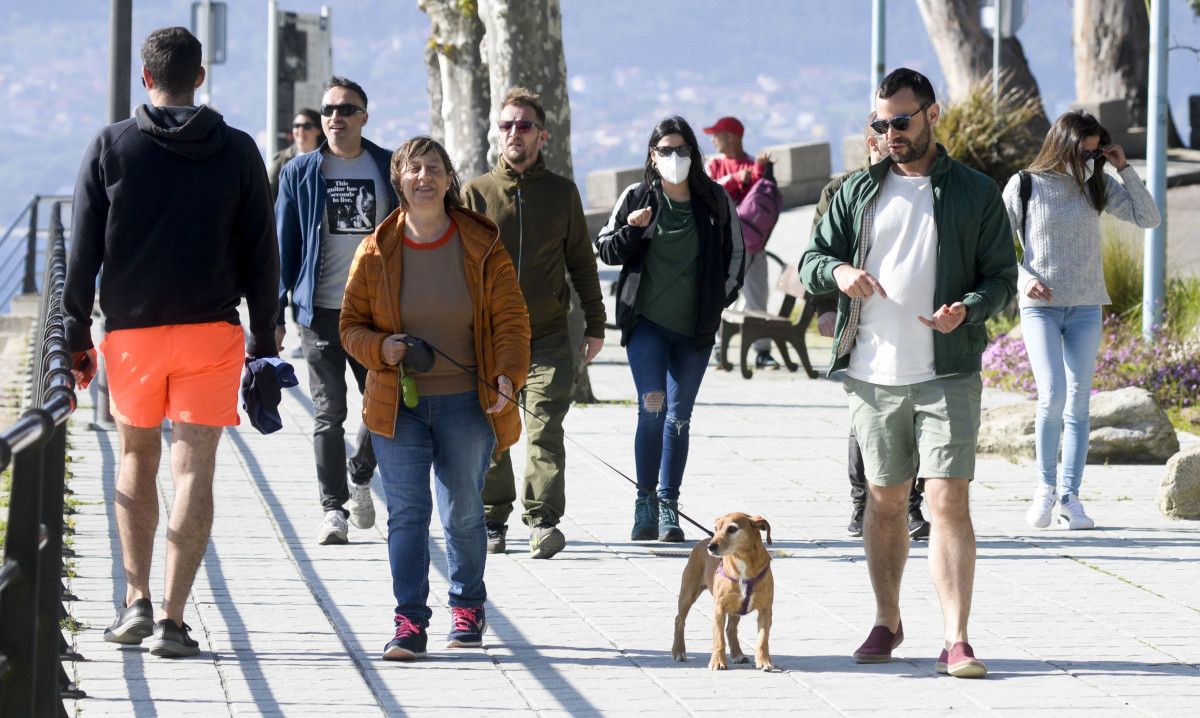 Gente paseando por el paseo de las playas en Marín