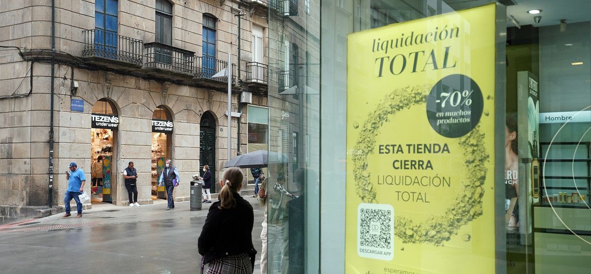 Cartel de peche de Douglas e, xusto en fronte, a tenda de Tezenis recentemente aberta