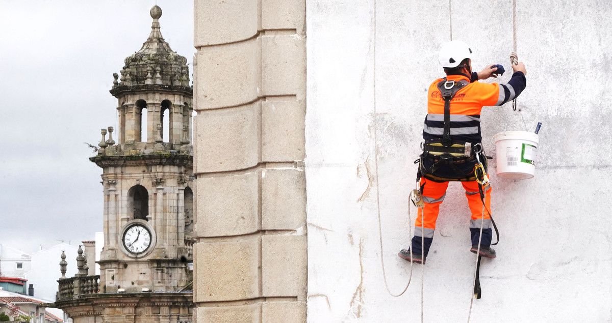 Un trabajador en la ciudad con la Peregrina de fondo