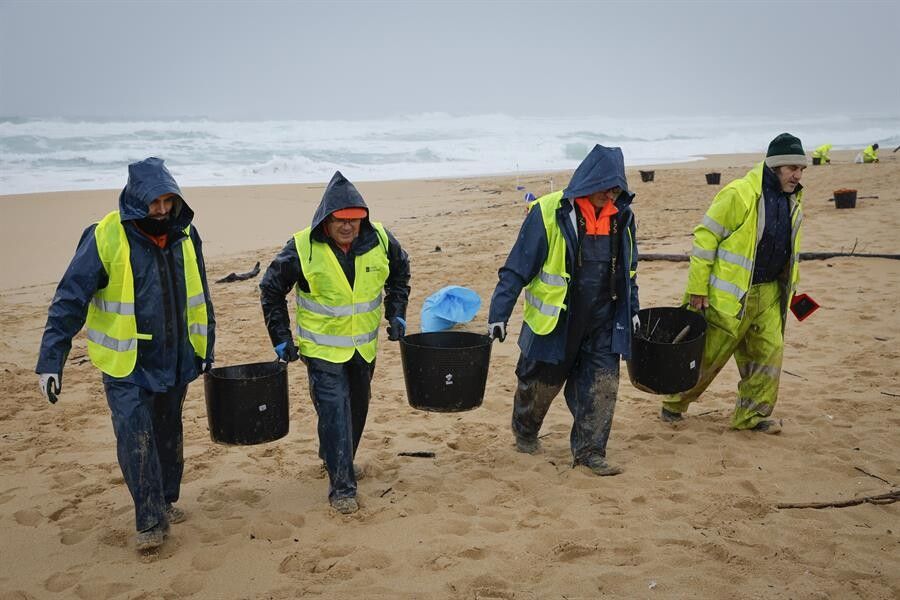 Operarios de empresas contratadas por la Xunta retiran los pellets en la playa de O Vilar (Corrubedo)