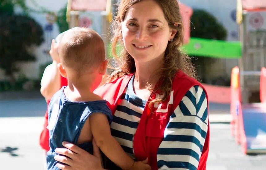 Una voluntaria de la Cruz Roja con un niño