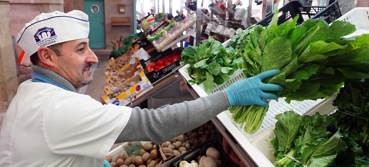 Pablo Cancela coloca as verduras no seu posto do mercado de abastos de Pontevedra, a froitería Pablo e María