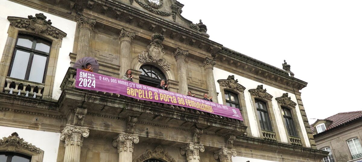 Despliegue de la pancarta del 8M en el balcón del Concello