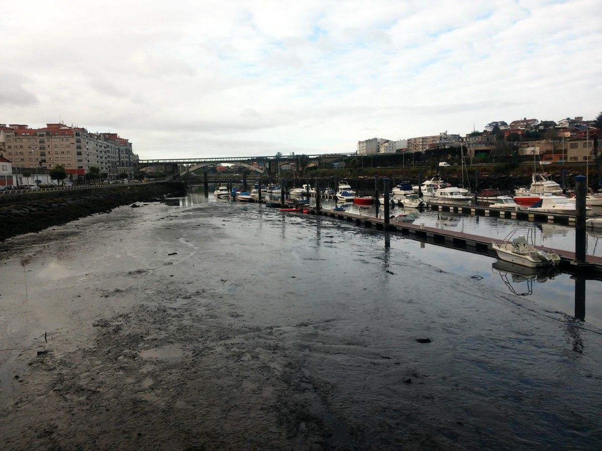 Magín Froiz y David Cal recogen lodo en el río Lérez