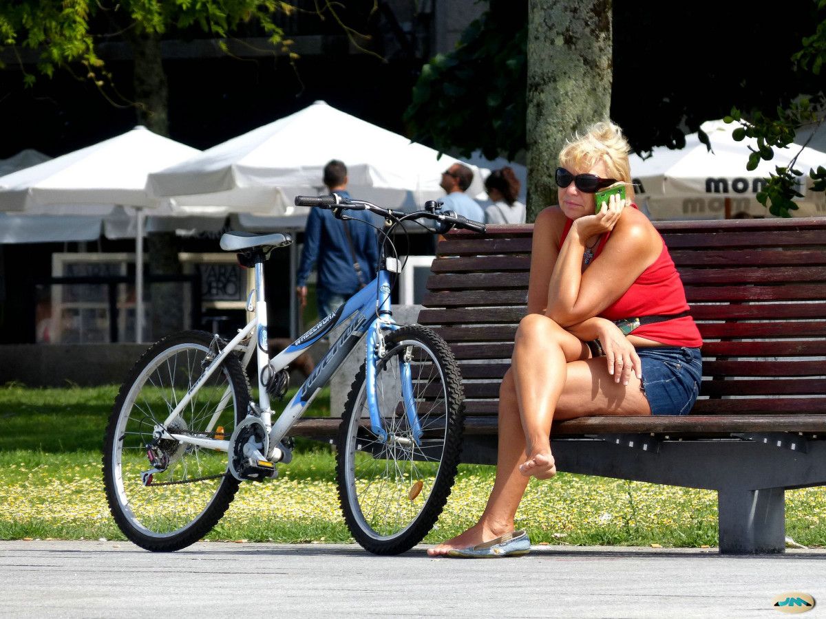 Unha muller descansa nun banco do parque