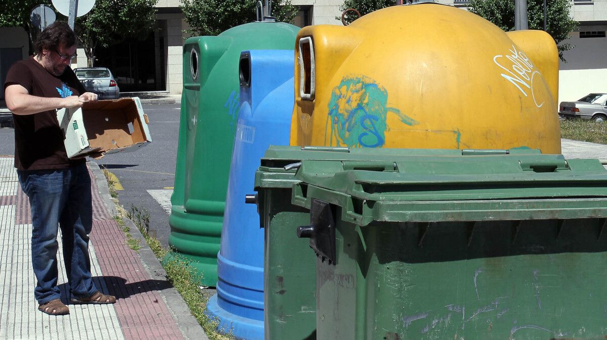 Un cidadán botando lixo aos contedores de reciclaxe