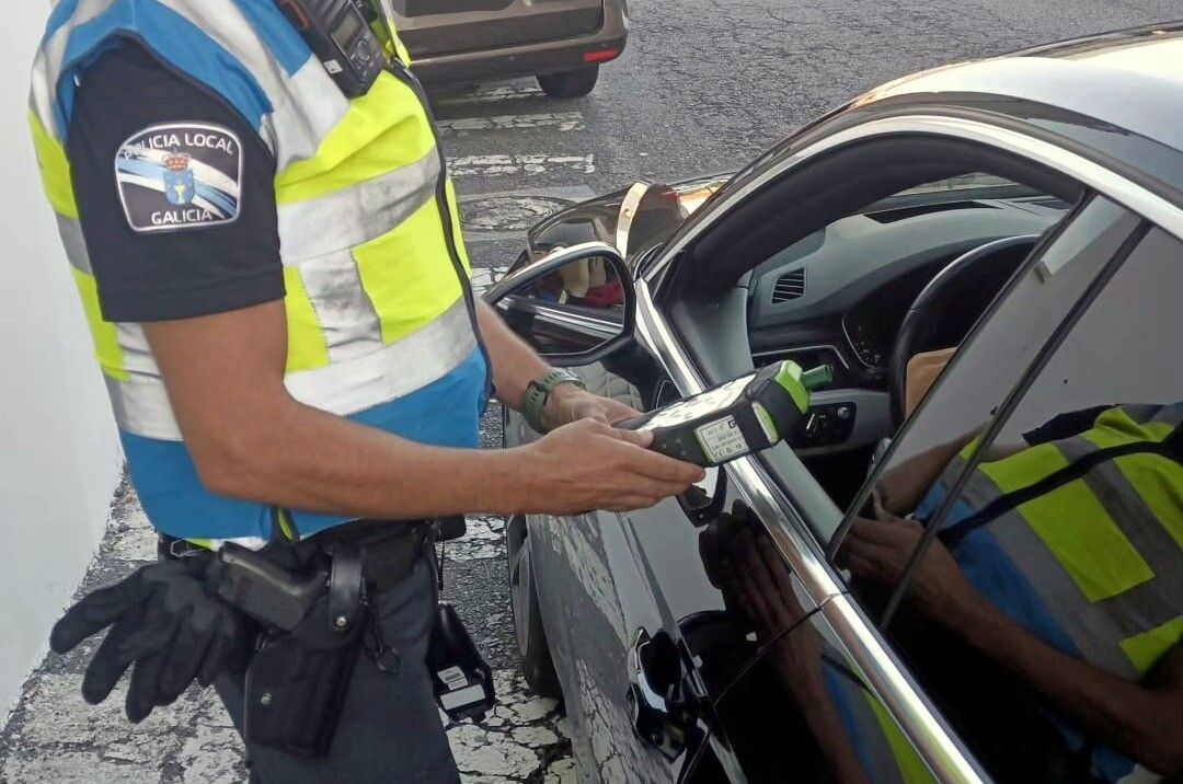 Un agente de la Policía Local realiza la prueba de alcoholemia al conductor