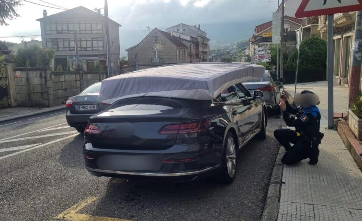 Multado por llevar un colchón agarrado con las manos sobre el techo del coche