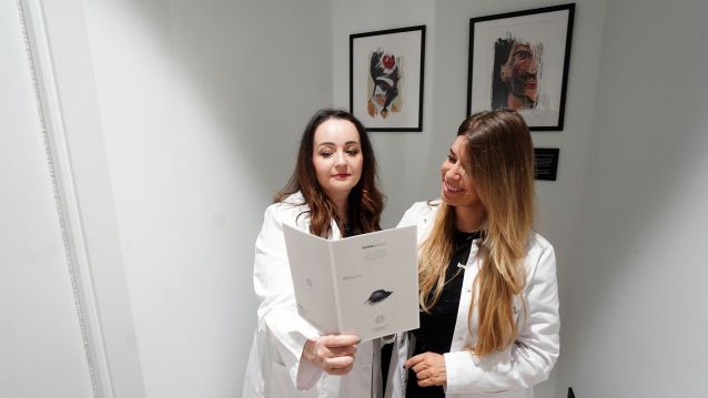 Doctoras en la sala solidaria Art for Dent revisando un cuaderno de diagnóstico facial