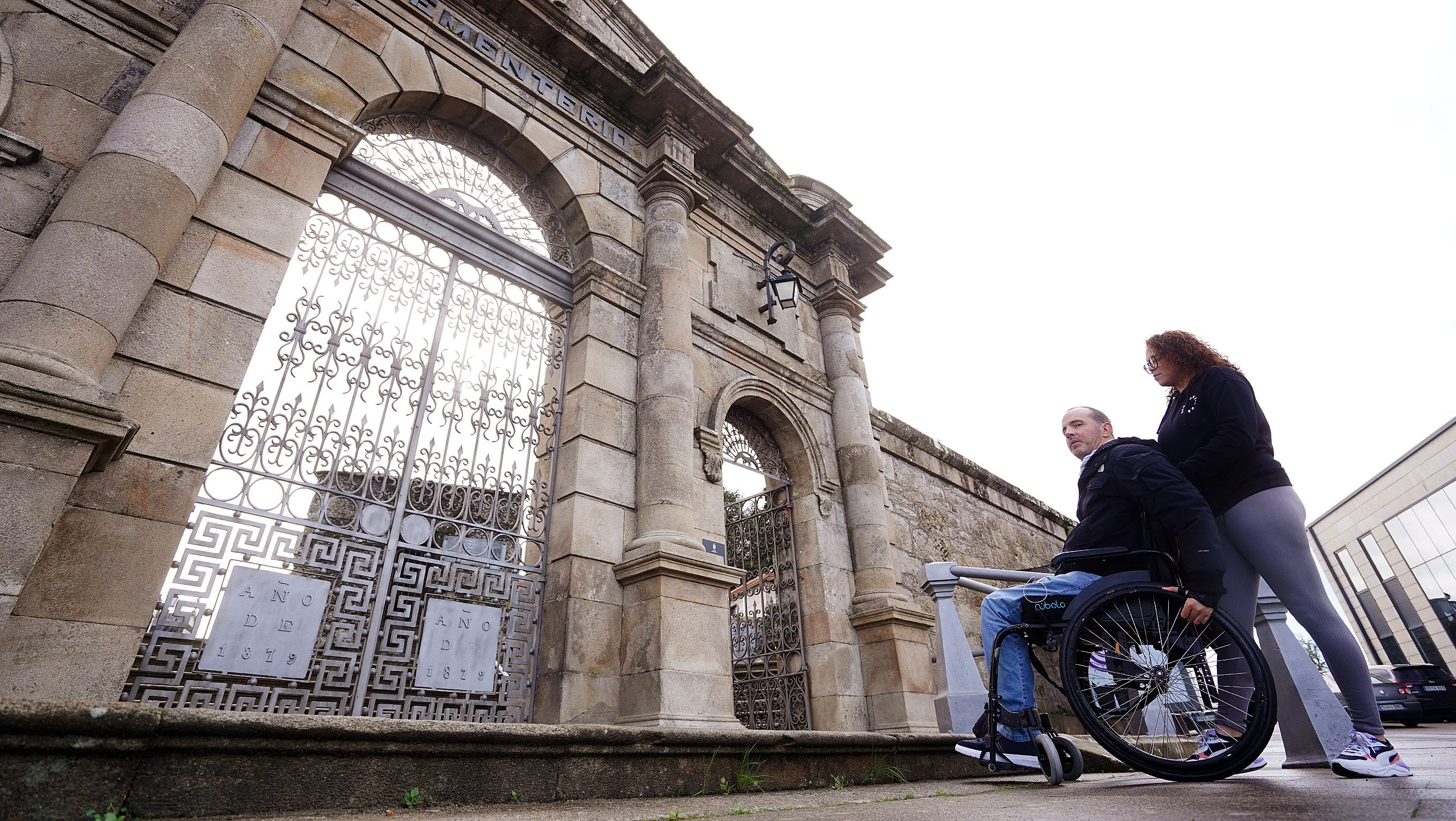 Paulo Fontán, presidente de Amizade, , acompañado da súa asistente, diante da porta principal do cemiterio de San Amaro