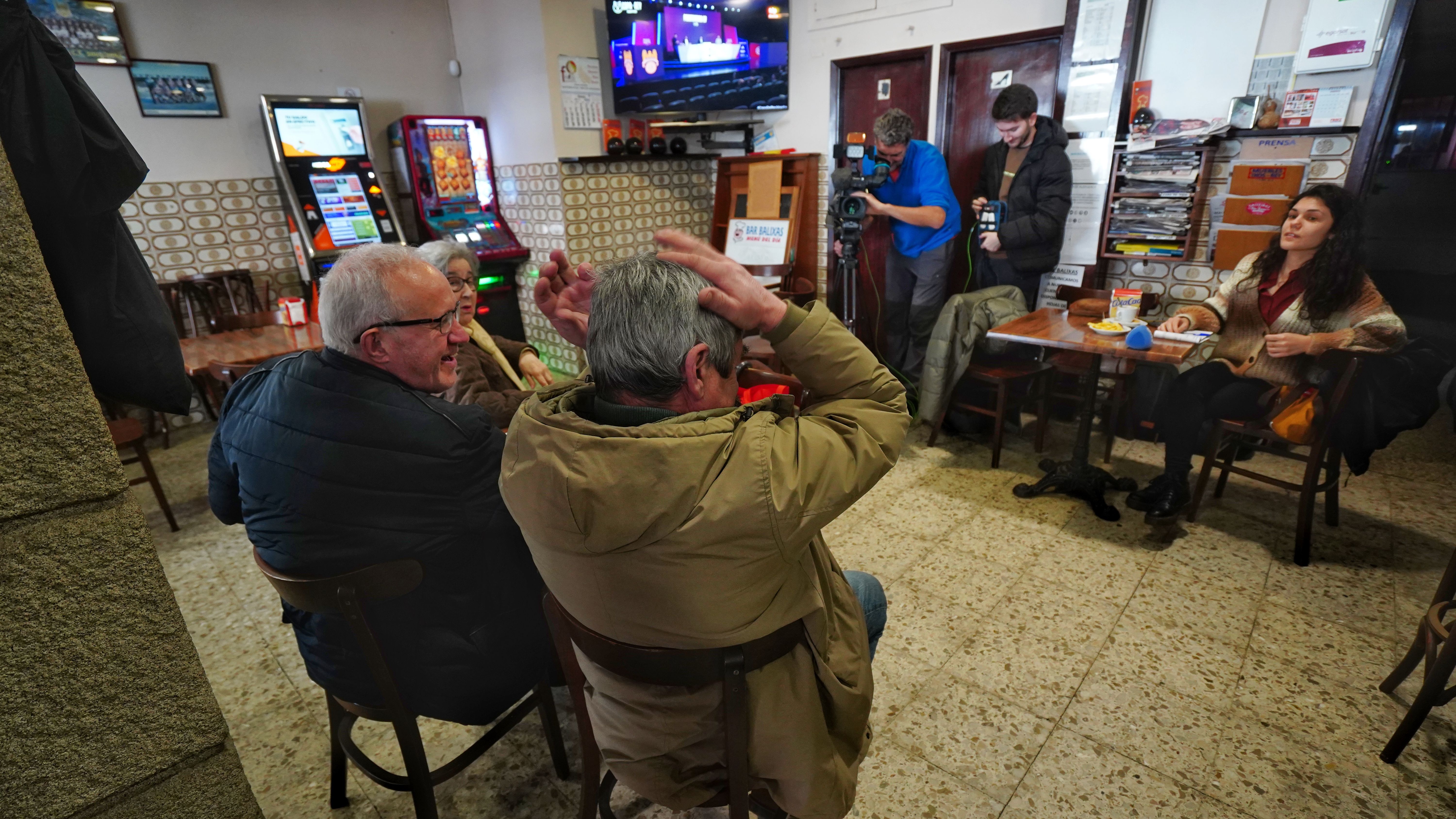 Afeccionados vendo o sorteo nun bar