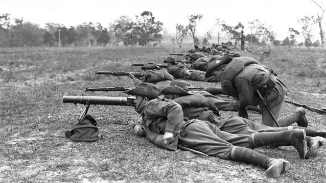 Soldados australianos apostados en liña, enfilando unha metralladora Lewis, en primeiro plano, e os fusís