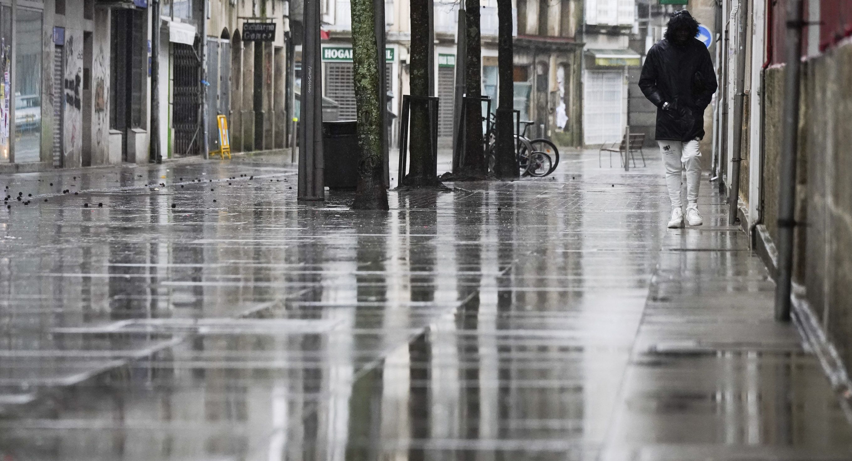 Persoa caminando bajo la lluvia este domingo 26