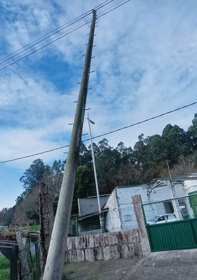 El poste de teléfono amenaza con caer sobre la carretera que pasa por delante de la casa de Dolores Candal