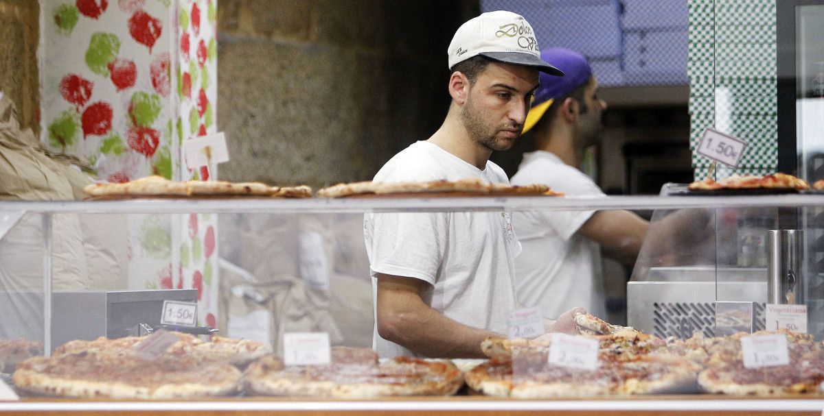 Un hombre trabajando en una pizzería