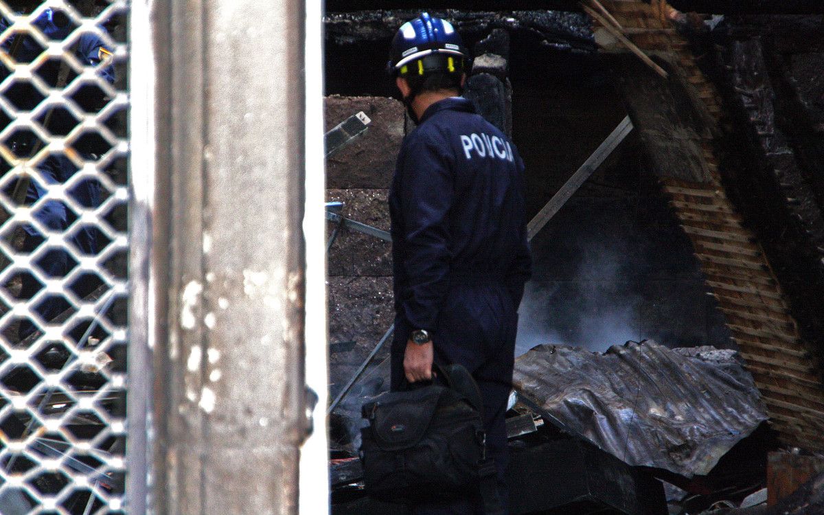 Axentes da policía científica revisan o edificio incendiado