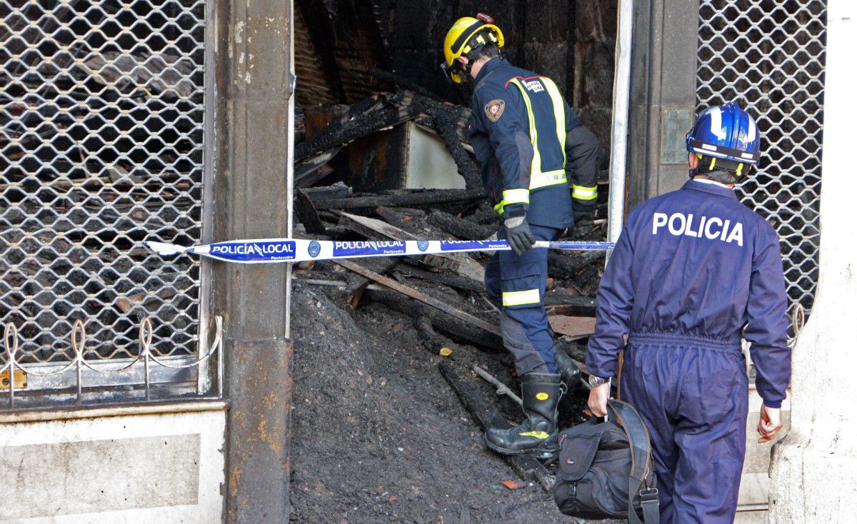 Axentes da policía científica revisan o edificio incendiado