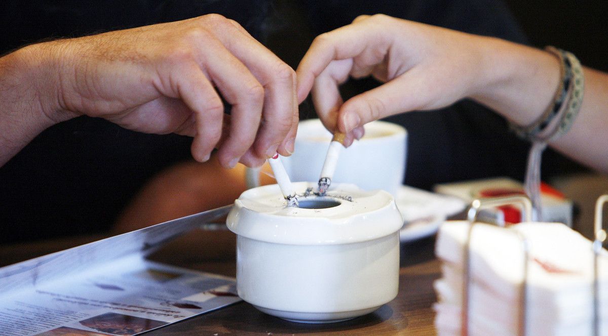 Apagando las colillas de los cigarrillos en el cenicero