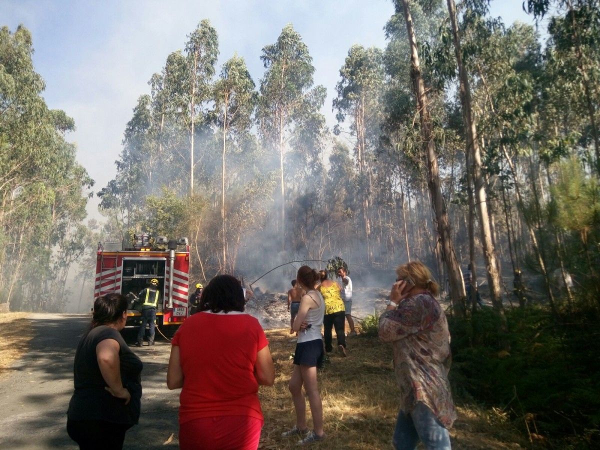 Efectivos de los Bomberos de Pontevedra sofocan el incendio en el lugar de Vilar, en Ponte Sampaio, con ayuda de los vecinos