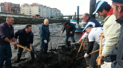 Magín Froiz y David Cal recogen lodo en el río Lérez